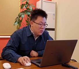 桌子上放着笔记本电脑的男人描述已自动生成